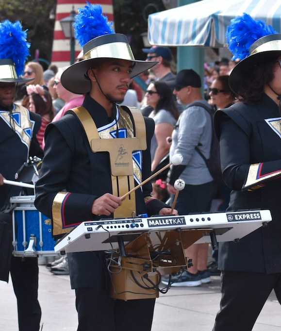 Marching performer using a MalletKAT electronic percussion controller with a Walkabout Carrier